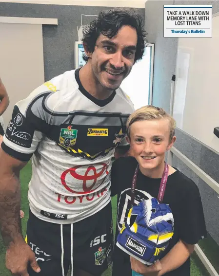  ??  ?? Johnathan Thurston gives Guy Brennan, 12, the son of Gold Coast Titans coach Garth Brennan, his headgear.