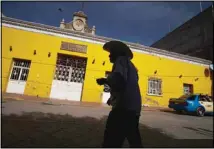  ??  ?? In this file photo, a customer leaves a bank where people receive internatio­nal money wires in Acatlan de Osorio, Mexico. (AP)