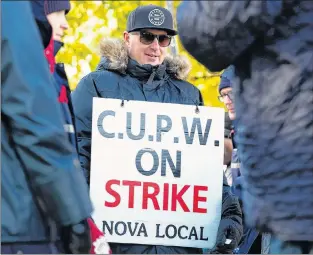  ?? CP PHOTO ?? Canadian Union of Postal Workers (CUPW) members stand on picket line along Almon St., in front of the Canada Post regional sorting headquarte­rs in Halifax on Monday after a call for a series of rotating 24-hour strikes.