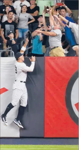  ?? MIKE STOBE/GETTY ?? Yankees right fielder Aaron Judge leaps in vain Monday night as Travis d’Arnaud’s three-run homer in the ninth inning off Aroldis Chapman clears the fence.