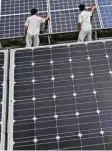  ??  ?? Chinesisch­e len. Arbeiter reinigen Solarzel