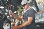  ?? Jon Gambrell, The Associated Press ?? Eric Ballard of Granby and the group beverage manager for Sunset Hospitalit­y, pours a beer at the Black Tap restaurant in Dubai, United Arab Emirates.