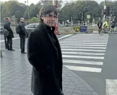  ?? MARK CARLSON/ THE ASSOCIATED PRESS ?? Ousted Catalan leader Carles Puigdemont walks along a street after giving a press conference in Brussels, on Tuesday.
