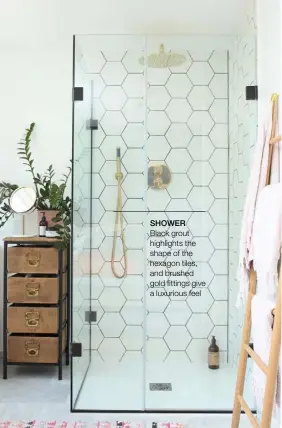  ??  ?? SHOWERBlac­k grout highlights the shape of the hexagon tiles, and brushed gold fittings give a luxurious feel