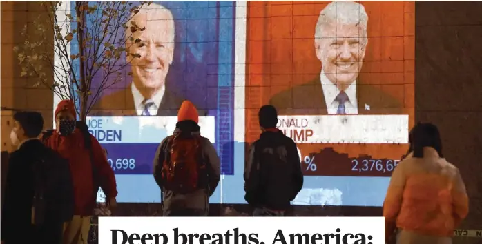  ?? OLIVIER DOULIERY/ AFP VIA GETTY IMAGES ?? People watch a big screen displaying election results on Tuesday near the White House.