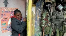  ?? PHOTO: REUTERS ?? A woman cries as she stands behind policemen during clashes between supporters of opposition leader Raila Odinga and policemen in Nairobi.