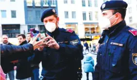  ?? AP PHOTO/LISA LEUTNER ?? Police officers check the vaccinatio­n status of visitors during a patrol on a Christmas market in Vienna, Austria, on Friday.