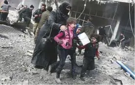  ?? AFP ?? Left: A Syrian woman and children run for cover amid the rubble of buildings following government bombing in Hammuriyeh town on Sunday.