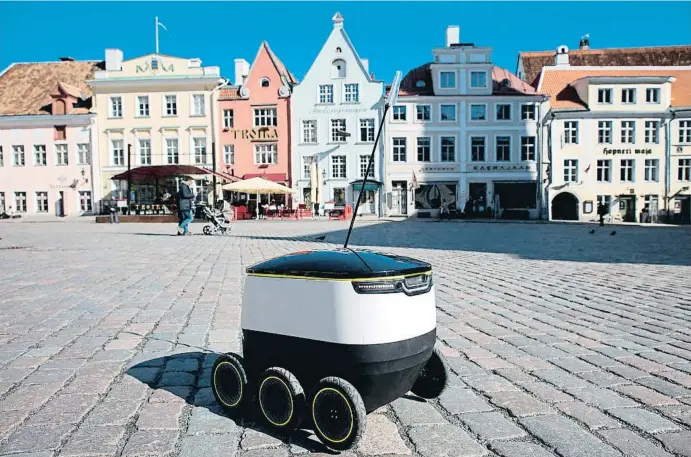  ??  ?? Un robot de repartimen­t elèctric es passeja per la plaça Major de Tallinn durant una sessió de prova