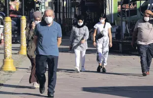  ??  ?? People wearing protective masks walk on a street in Gümüşhane, northern Turkey, Sept. 24, 2020.