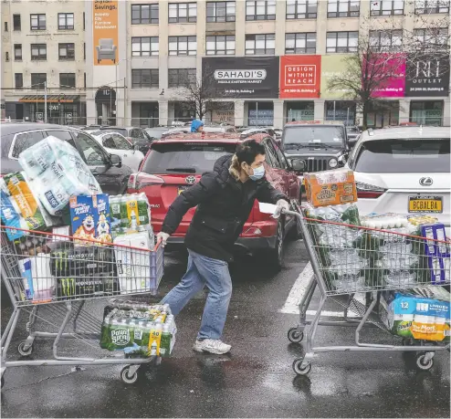  ?? Victor J. Blue / Gett
y Imag
es ?? A shopper wheels away purchases at a Costco store in Brooklyn as the coronaviru­s outbreak hits New York hard.