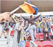  ?? — AFP — AFP photo ?? Supporters of Mezokovesd cheer their team during the national championsh­ip’s football match between DVTK and Mezokovesd in the DVTK stadium of Miskolc town, Hungary. Hungarian spectators will from this weekend fill the stands of the country’s football stadiums - a first in Europe where the resumption of several national championsh­ips was done behind closed doors.