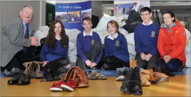  ?? Photo by Declan Malone ?? Transition Year pupils at Pobalscoil Chorca Dhuibhne have collected over 1,500 pairs of shoes which will be donated to the Jacket Off Your Back charity for distributi­on to refugees in Europe. Seen here with some of the many sacks of shoes are, from...