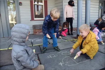  ?? TANIA BARRICKLO — DAILY FREEMAN ?? Preschoole­rs in the Magic Circle School at the YWCA of Kingston and Ulster County in Kingston, N.Y., show their enthusiasm when allowed to draw with chalk out on the front entrance. Oscar Renard, son of Amy Mikel and Justin Renard from Kingston, is at left, and his twin, Henri Renard, is at right. With them is Robert “Bobby” DuBois, center, son of Kristina and Robert DuBois of Tillson.