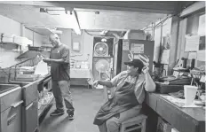  ?? YALONDA M. JAMES/ THE COMMERCIAL APPEAL ?? Timmy Vester, left, completes a to-go order, while Suga Tard, owner of Suga's Diner, takes a break during an August workday in Stanton.