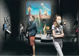  ?? ANA JIMÉNEZ ?? Visitantes con mascarilla en el CaixaForum; al fondo, una obra de Dalí