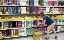  ?? JAY JANNER / AMERICAN-STATESMAN ?? Walmart associate LeAnna Walters restocks shelves at an Austin store. The retail giant plans a $277 million investment in Texas this year.