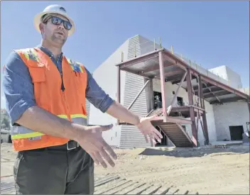  ?? Signal file photo ?? Project Manager Bryan Aylor of TELACU Constructi­on Management describes the work in progress on the new Saugus High School Performing Arts Center during a tour to view progress during constructi­on in Saugus last year.