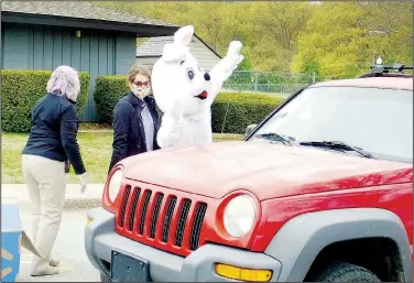  ?? (File Photo/NWA Democrat-Gazette) ?? A curbside Easter Bunny waves to Property Owners Associatio­n members during the first-ever curbside Property Owners Associatio­n Easter Egg Hunt in April 2020.