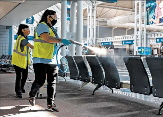 ?? BRIAN CASSELLA/CHICAGO TRIBUNE PHOTOS ?? A cleaning crew demonstrat­es the disinfecti­ng procedure for United gate areas Thursday at O’Hare Internatio­nal Airport in Chicago.