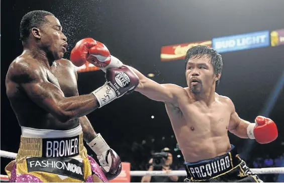  ?? / JOE CAMPOREALE ?? Manny Pacquiao throws a punch at Adrien Broner during their WBA welterweig­ht title fight at MGM Grand Garden Arena. Pacquiao won via unanimous decision. He has challenged long time foe Floyd Mayweather to come out of retirement and fight him.