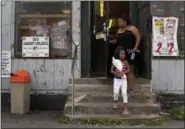  ??  ?? An anti violence sign, created by former gangsters hangs on a window of a corner convenienc­e store where woman and her daughter finished shopping, Monday, Aug. 21, 2017, in the South Side neighborho­od of Syracuse, N.Y. Syracuse is a modestly sized city...