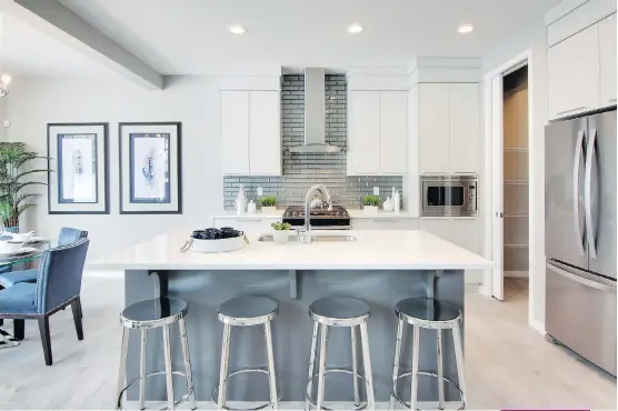  ?? PHOTOS: CEDARGLEN HOMES ?? The Carbon 2’s stylish kitchen features a large island with extended eating bar, full-height tile backsplash and a pantry.
