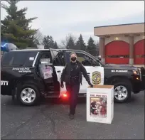  ??  ?? Mt. Pleasant Public Informatio­n Officer, Autume Balcom takes donated toys from community members to fill police vehicle for the Mt. Pleasant Police Department’s ‘Cram a Cruiser’ event.