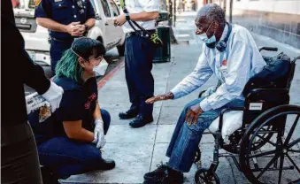  ?? Jessica Christian/The Chronicle 2021 ?? S.F. Street Crisis Response Team clinician Stephanie Chiri talks with Paul Lumpkin after he stopped the team to ask for resources near the corner of 16th and Mission streets.