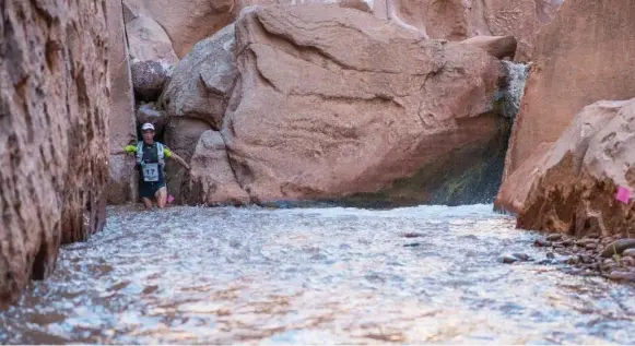  ?? PHOTOS COURTESY PAUL BORLINHA ?? Paul Borlinha wades through deep water as he crosses rock formations in the Atacama Desert during a 250-kilometre, seven-day ultramarat­hon in Chile.