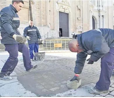  ?? JESÚS MARÍN ?? Operarios de los planes de empleo de la Junta, arreglando el suelo de la plaza de la Catedral.