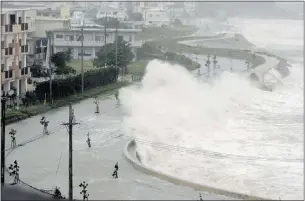  ??  ?? High waves pound the seawall in Yonabaruch­o, Okinawa, in Japan on Sunday. Residents were being told to stay indoors.