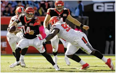  ?? RON SCHWANE / ASSOCIATED PRESS ?? Bengals quarterbac­k Andy Dalton scrambles to avoid Browns defensive tackle Trevon Coley (right) in the second half of the Bengals’ 31-7 victory in Cleveland on Sunday.