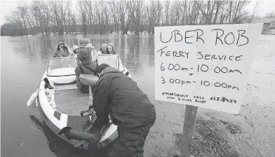  ?? ANDREW VAUGHAN / THE CANADIAN PRESS ?? Rob Dekany, known as Uber Rob, ferries stranded passengers at Darlings Island, N.B., on Thursday as the Kennebecas­is River flooded the only road into the community. Dekany has refused to accept any payment.