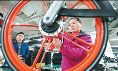  ?? PROVIDED TO CHINA DAILY ?? Workers fine-tune a Mobike at a production line in Hengyang, Hunan province.