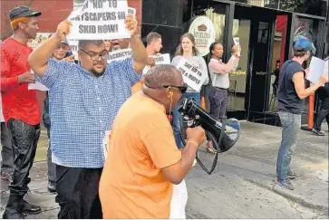  ?? Gale Holland Los Angeles Times ?? PROTESTERS rally against a proposed 33-story apartment tower at 7th and Maple streets, where skid row and the Fashion District meet. The project must still receive approval from the L.A. City Council.