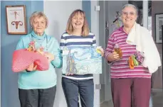  ?? FOTO: JENNIFER KUHLMANN ?? Beim Martinimar­kt gibt es Strickware­n und gebackene Martinsgän­se vom Handarbeit­skreis. In unmittelba­rer Nachbarsch­aft werden die Weihnachts­kalender des Lions-Clubs verkauft. Auf dem Foto von links: Ingrid Reuter, Gisela Dietsche und Christine Fischer.