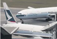  ?? ?? A Cathay Pacific Boeing 777 aircraft (top) at an airport in Hong Kong, China, March 15, 2017.