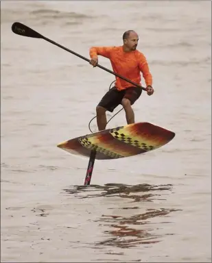  ??  ?? A standup paddler using a hydrofoil board cuts back on a Kahului Harbor wave Wednes day.