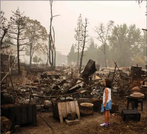  ?? (The New York Times/Alisha Jucevic) ?? Izel Ramos-Gonzalez, 7, looks over her grandmothe­r’s backyard in Phoenix, Ore., on Sept. 12. Area officials estimated that nearly 1,800 houses and businesses were destroyed in the Almeda Fire last week, which burned through parts of Phoenix and nearby Talent.