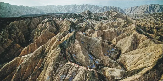  ?? YU HAI / FOR CHINA DAILY; ?? Above: The Chinese mountain petroleum exploratio­n team work on the two-dimensiona­l seismic exploratio­n project in Tuziluok, Tarim, Xinjiang Uygur autonomous region, Sept 1, 2017.