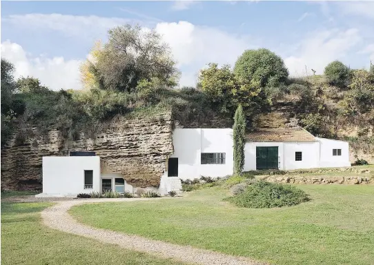  ?? PHOTOS: YATZER ?? A cave near Cordoba, Spain, has been refurbishe­d into a modern rural home. The building’s architects contrasted the natural stone surface with pristine whitewashe­d walls. The naturally uneven front lawn deserves a special note, providing residents with...