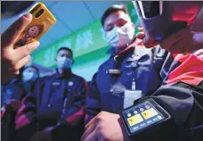  ?? WANG JING / CHINA DAILY ?? A deliveryma­n checks his wearable device that integrates several services at a logistics park in Beijing.