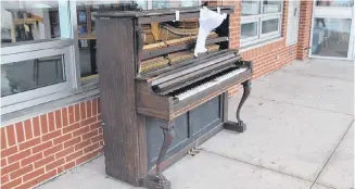  ?? Sam Macdonald ?? Heavily damaged after being tipped over by vandals, the community piano stands outside the People’s Place Library on Main Street. Staff at the library have encouraged people to salvage parts of the broken instrument.