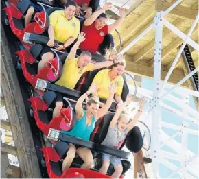  ?? JOE BURBANK/STAFF PHOTOGRAPH­ER ?? Thrill-seeking guests get the first ride Friday on the Mine Blower during the debut of the wood &amp; steel roller coaster at Fun Spot in Kissimmee. The coaster is 82 feet tall and 2,256 feet long — with top speeds of 48.5 mph.