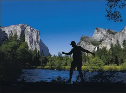  ?? JIM GENSHEIMER — STAFF FILE PHOTO ?? With El Capitan and Bridal Veil Falls in the background, Karl Bastian, of Parker, Colo., takes a walk on a log on the Merced River in 2017 at Yosemite National Park.