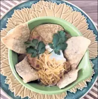  ?? ORANGE COUNTY REGISTER ?? Adorned with tortilla chips, shredded cheese, fresh cilantro and sour cream, Refried Bean Soup is a classic easy-to-make comfort dish.