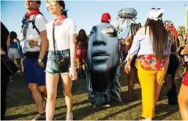  ??  ?? A fan walks through the festival grounds with a Beyonce cloth draped over during the Coachella Music and Arts Festival.