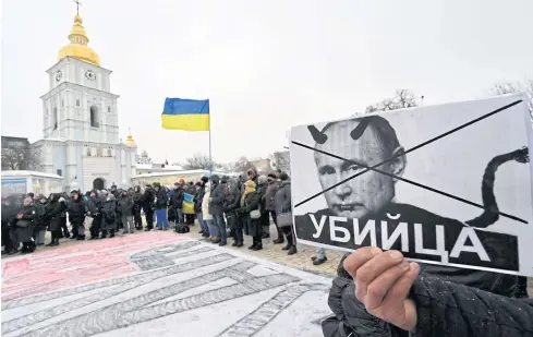  ?? AFP ?? A demonstrat­or in Kiev holds a placard of Russian President Vladimir Putin reading ‘Killer’. Indeed, some observers think recent moves by the Kremlin abetted by Western inaction could lead to the demise of Nato as a bulwark against Russia.