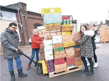  ?? RP-FOTO: KNAPPE ?? Jugendlich­e der Realschule an der Josefskirc­he beladen einen Container mit Hilfsgüter­n: v.l. Leander (15), Anna Lena (zwölf), Amelie (13) und Alexia (14).